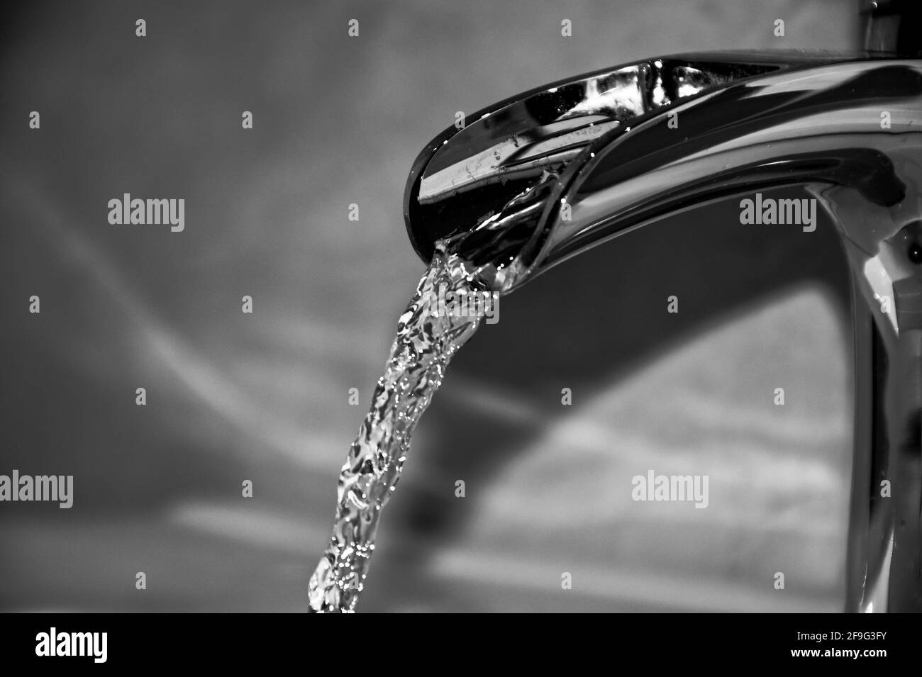 Robinet en cascade avec eau fluide en noir et blanc Banque D'Images