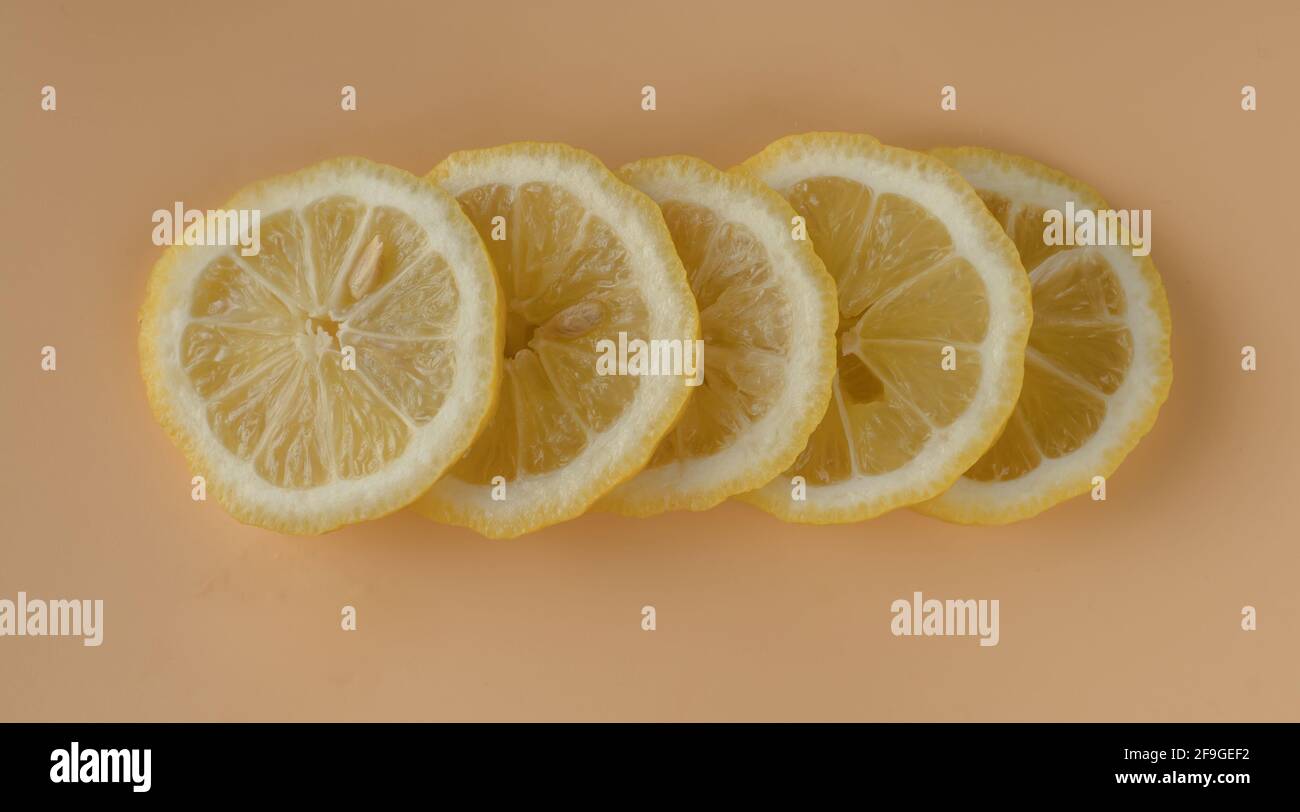 Morceaux de citron, citron coupé en tranches sur fond d'abricot Banque D'Images