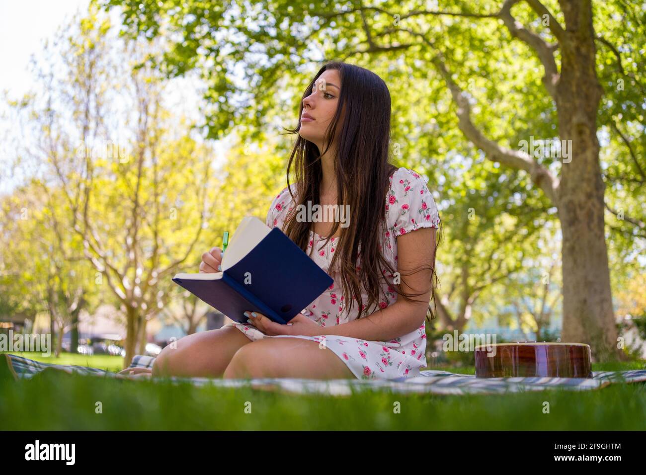 Magnifique auteur-compositeur Latina Teen dans le parc au printemps léger robe Banque D'Images