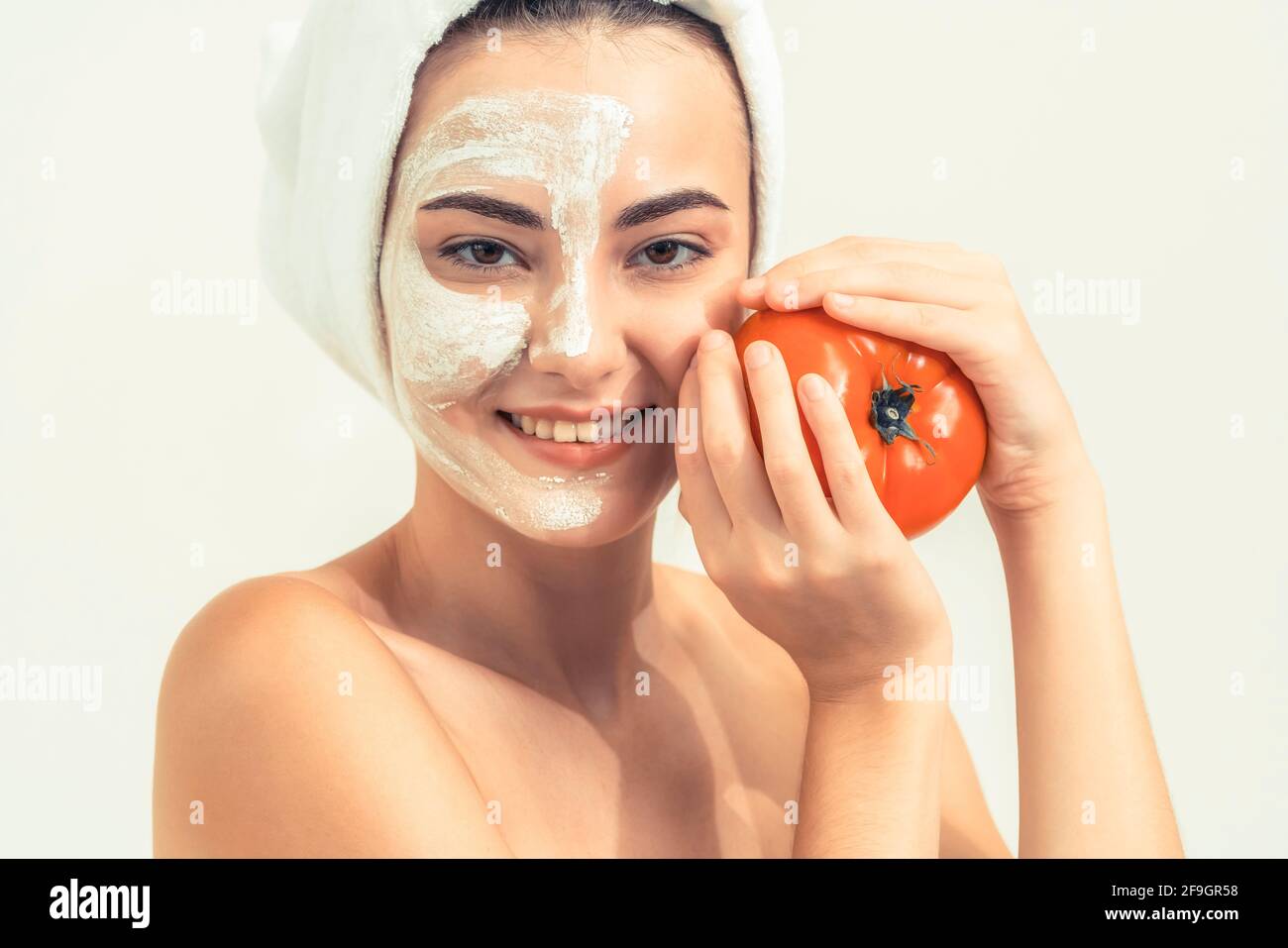 Belle femme ayant un traitement de masque facial avec extrait de crème de tomate montrant l'avantage du traitement de la nature. Cosmologie anti-âge, soins du visage Banque D'Images
