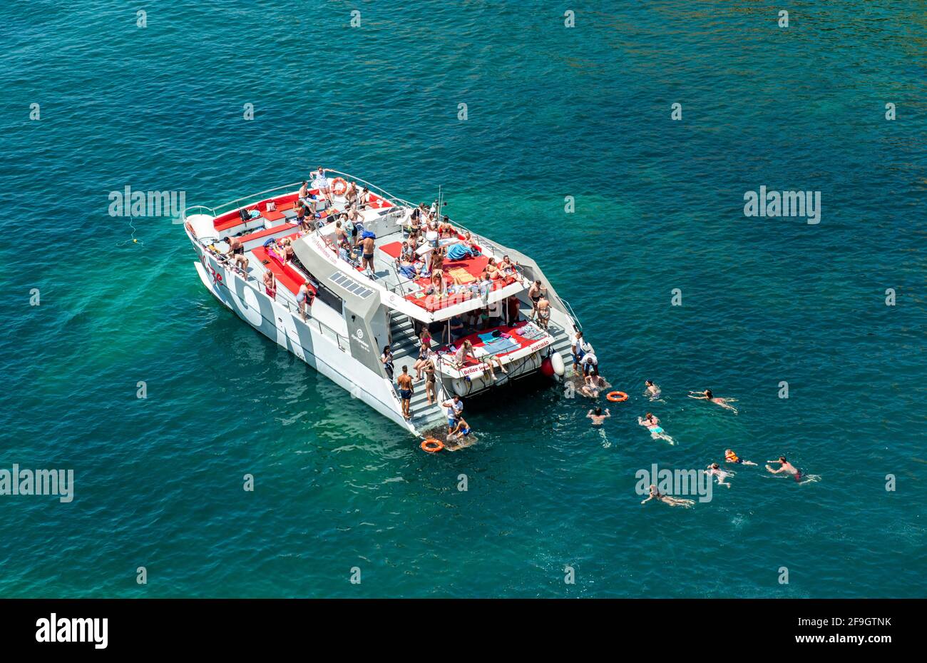 Grand bateau d'excursion, les personnes nageant dans la mer turquoise, Algarve, Lagos, Portugal Banque D'Images