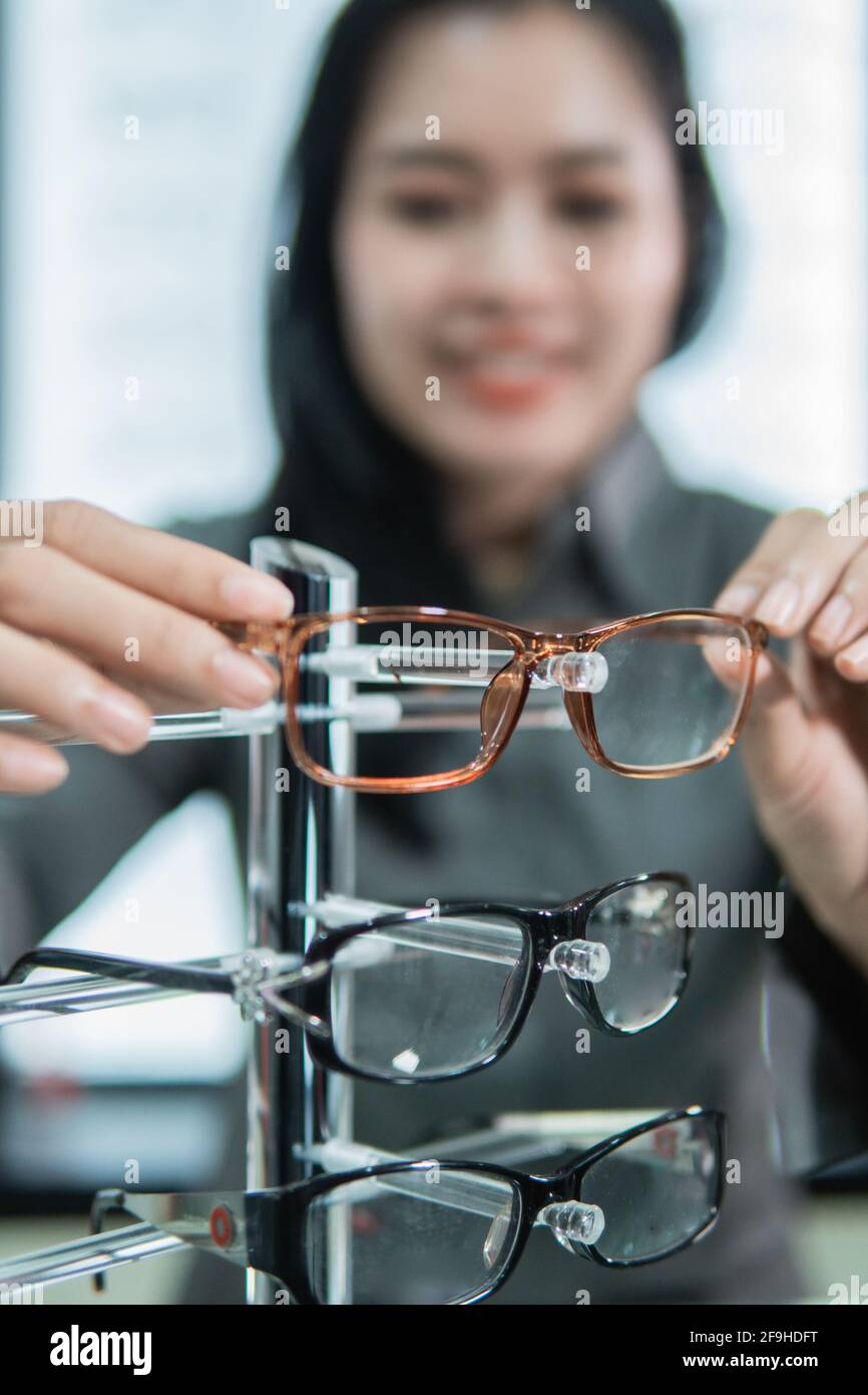 mise au point sélective des montures de lunettes placées sur une étagère par une cliente après les avoir essayée Banque D'Images