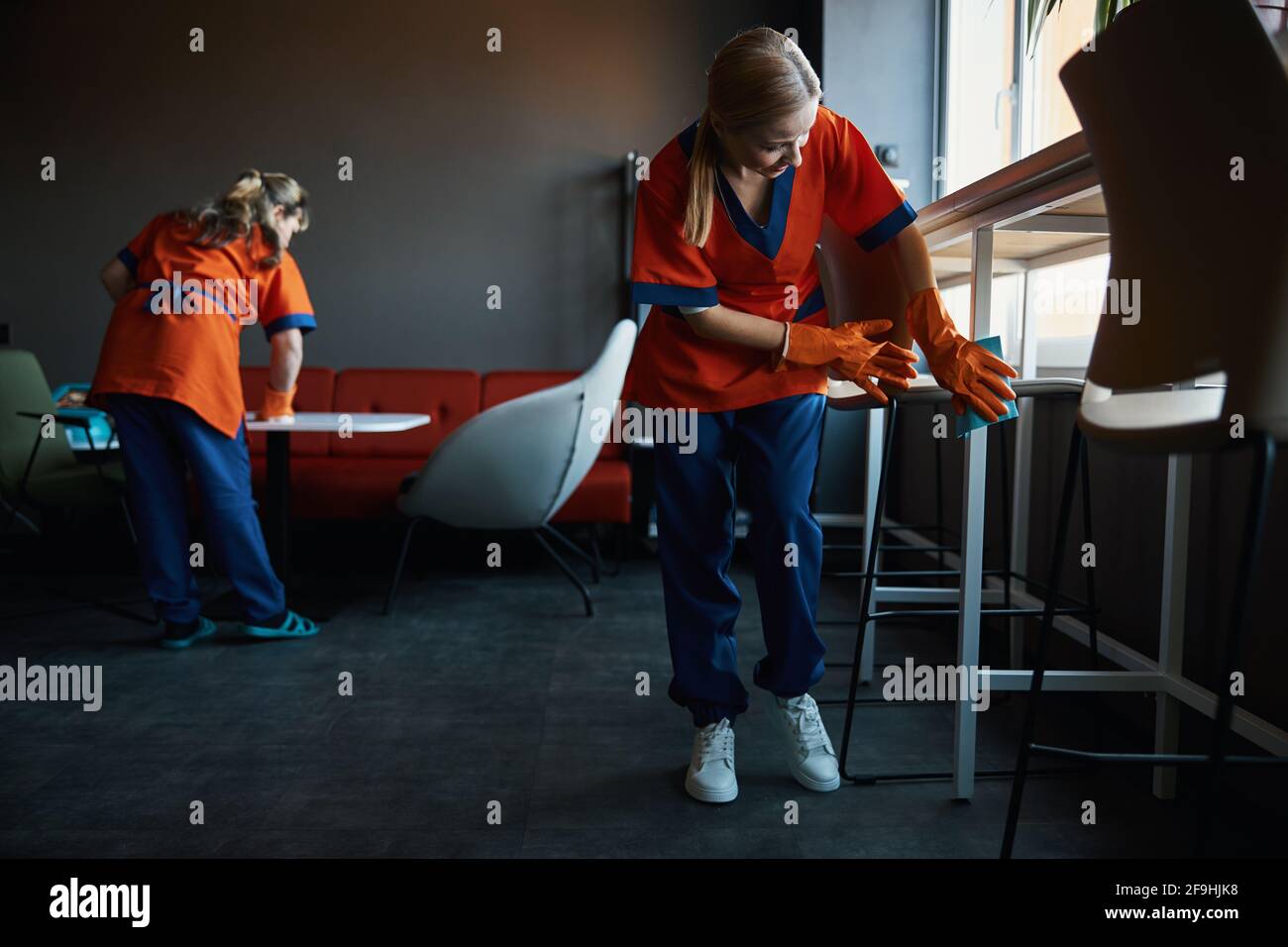 Femme blonde concierge nettoyage d'une cafétéria de bureau Banque D'Images