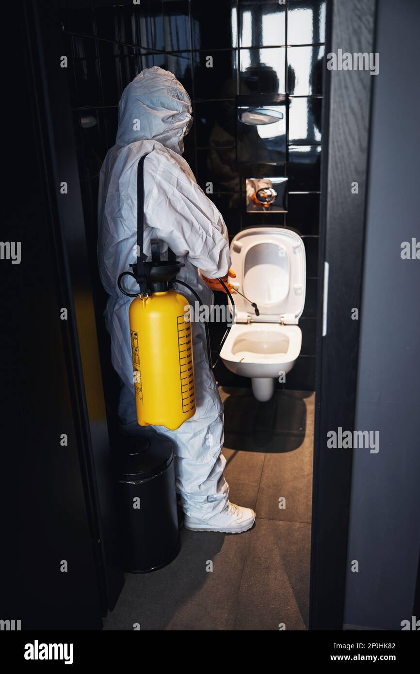 Un concierge qualifié effectuant le nettoyage antiviral dans les toilettes  publiques Photo Stock - Alamy