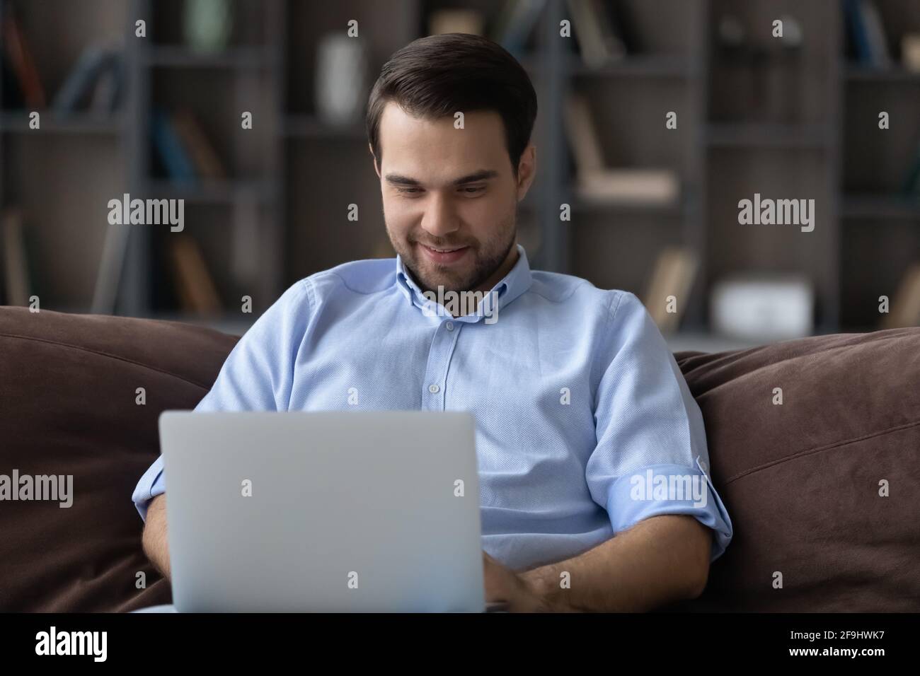 Un homme de race blanche satisfait de travailler sur un ordinateur portable à la maison Banque D'Images