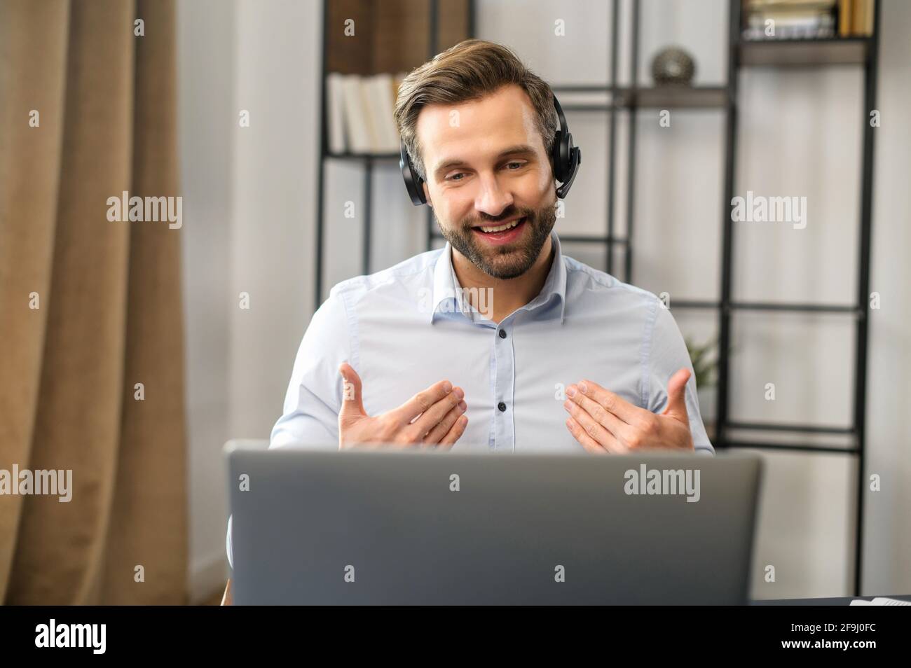 Positif concentré millennais slaves de type portant des écouteurs, à l'écoute du client tout en planifiant une stratégie de secours, de jeunes hommes d'affaires focalisés prend part à une conférence en ligne éducative Banque D'Images
