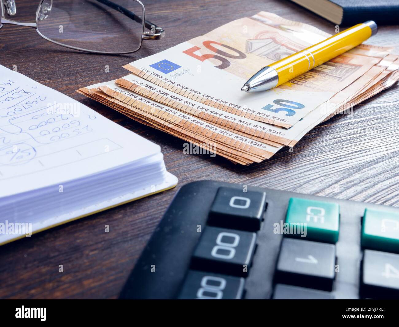 Billets en euros et bloc-notes avec calculs. Comptabilité et finance des petites entreprises. Banque D'Images