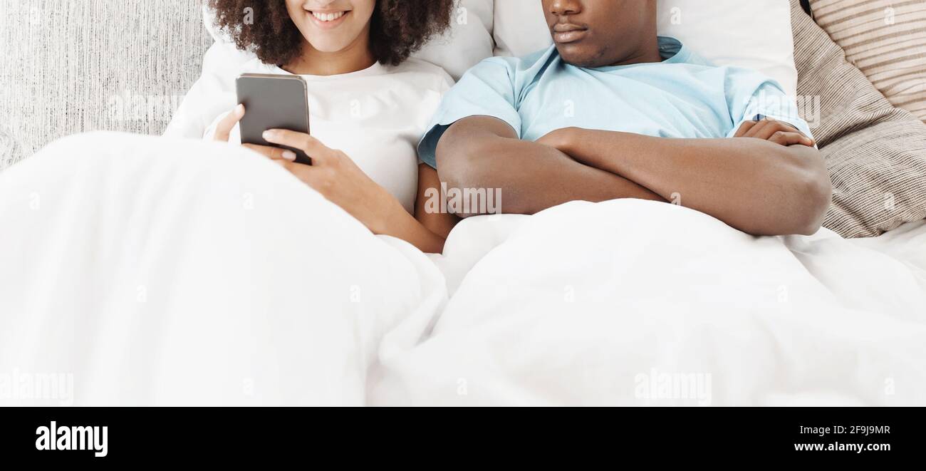 Chat en ligne au lit, les problèmes de relation et la jalousie Banque D'Images