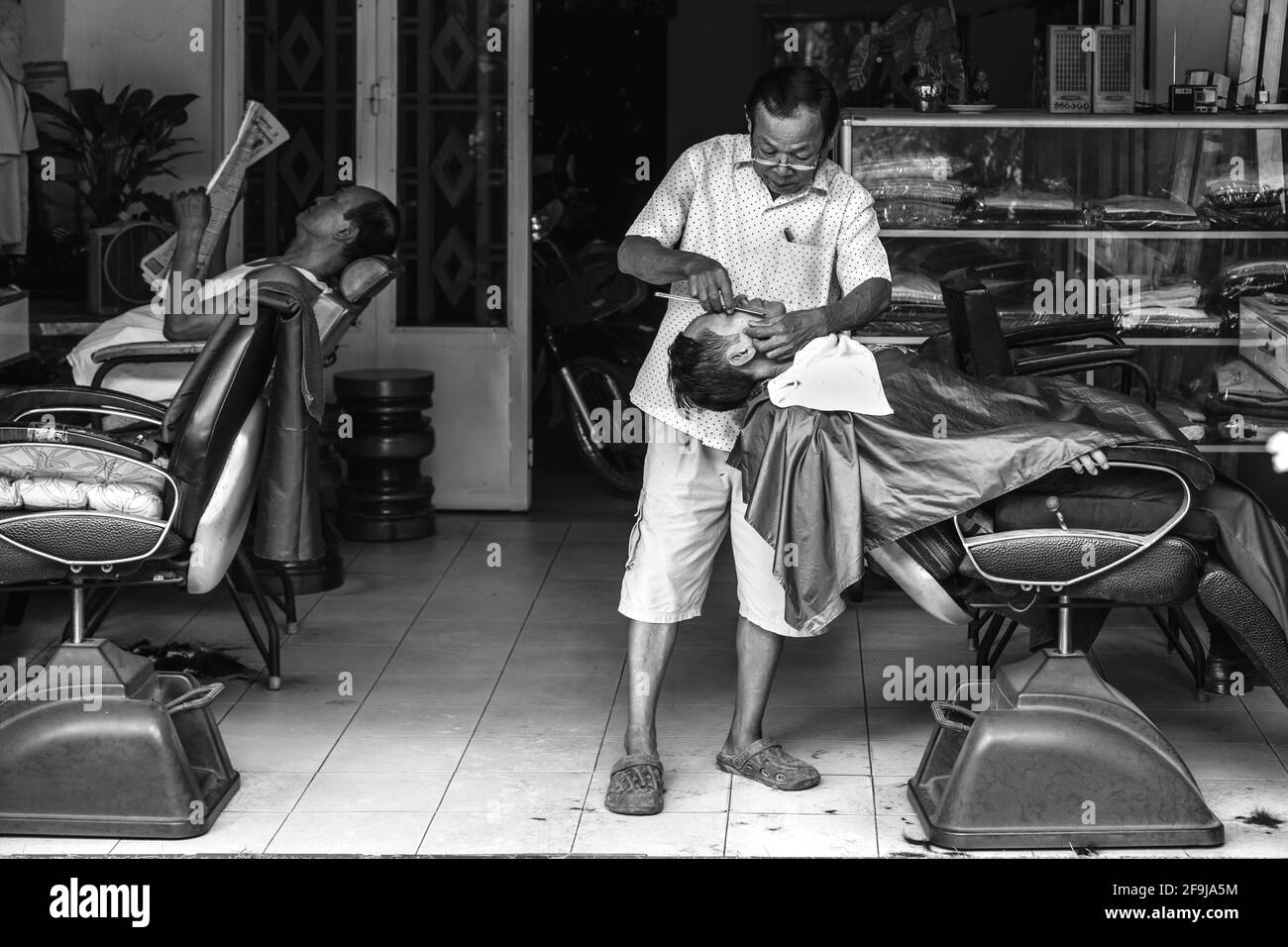 Un homme d'avoir un rasage humide dans une boutique de coiffeur, Phnom Penh, Cambodge. Banque D'Images