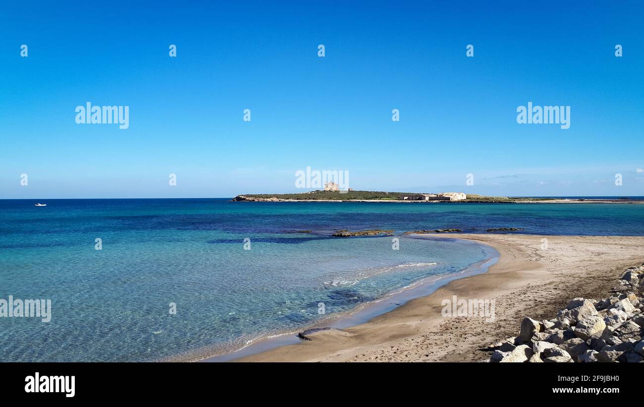 Petite plage dans la ville de Portopalo, Sicile avec l'île de Capo