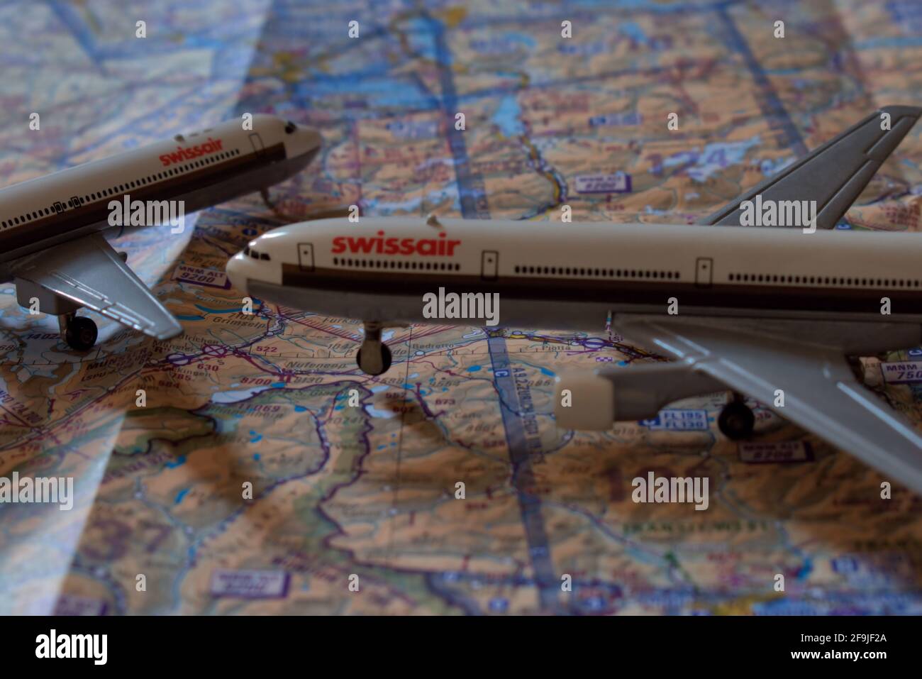 Jouets d'avion de Swissair placés sur une carte de navigation aérienne 25.3.2021 Banque D'Images