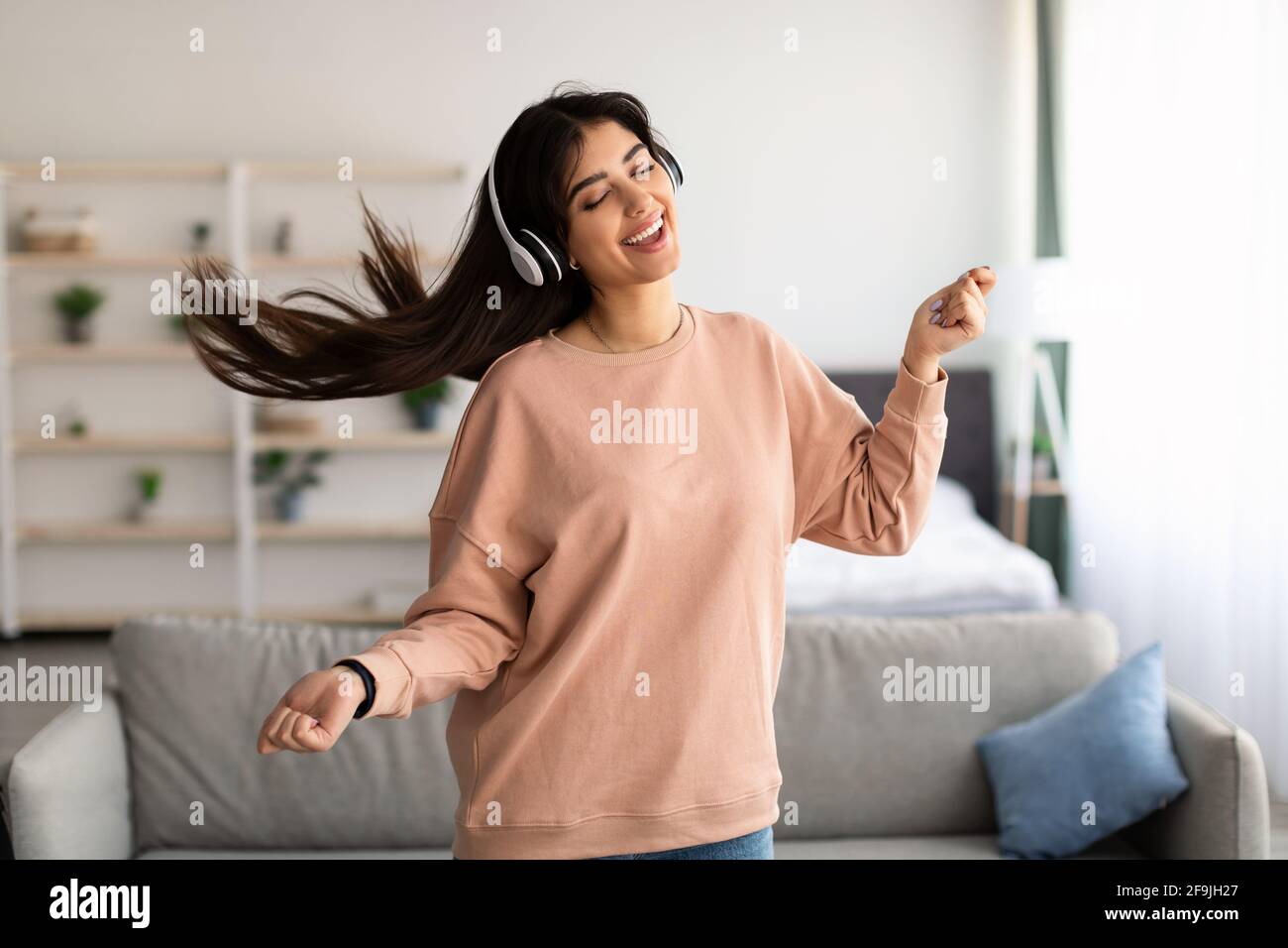 Jeune femme dansant et portant un casque sans fil Banque D'Images