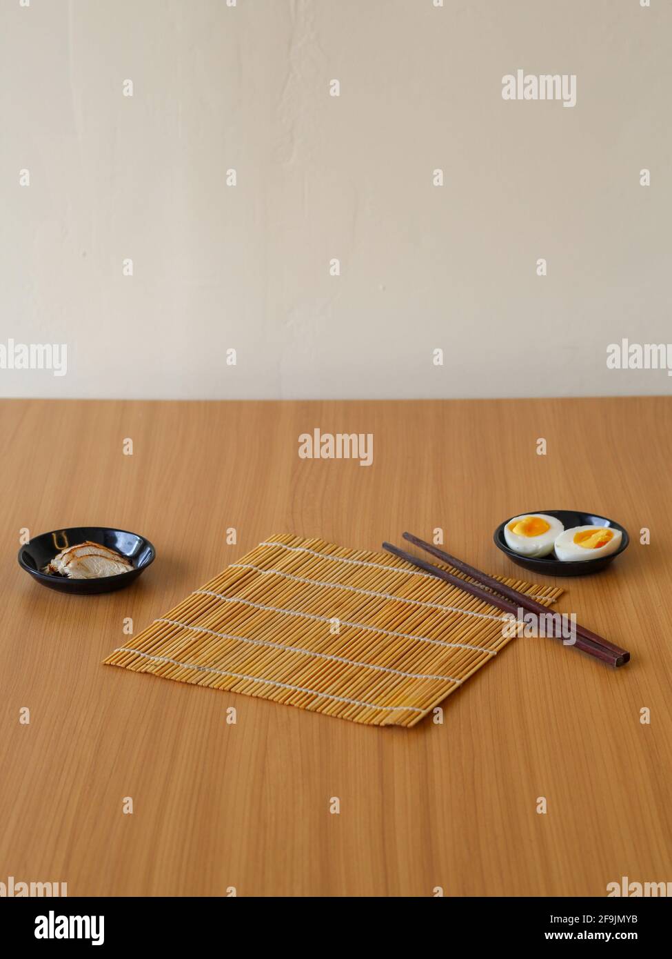 Ingrédients des recettes japonaises. Tranches de poulet et œuf dur sur la soucoupe noire Banque D'Images