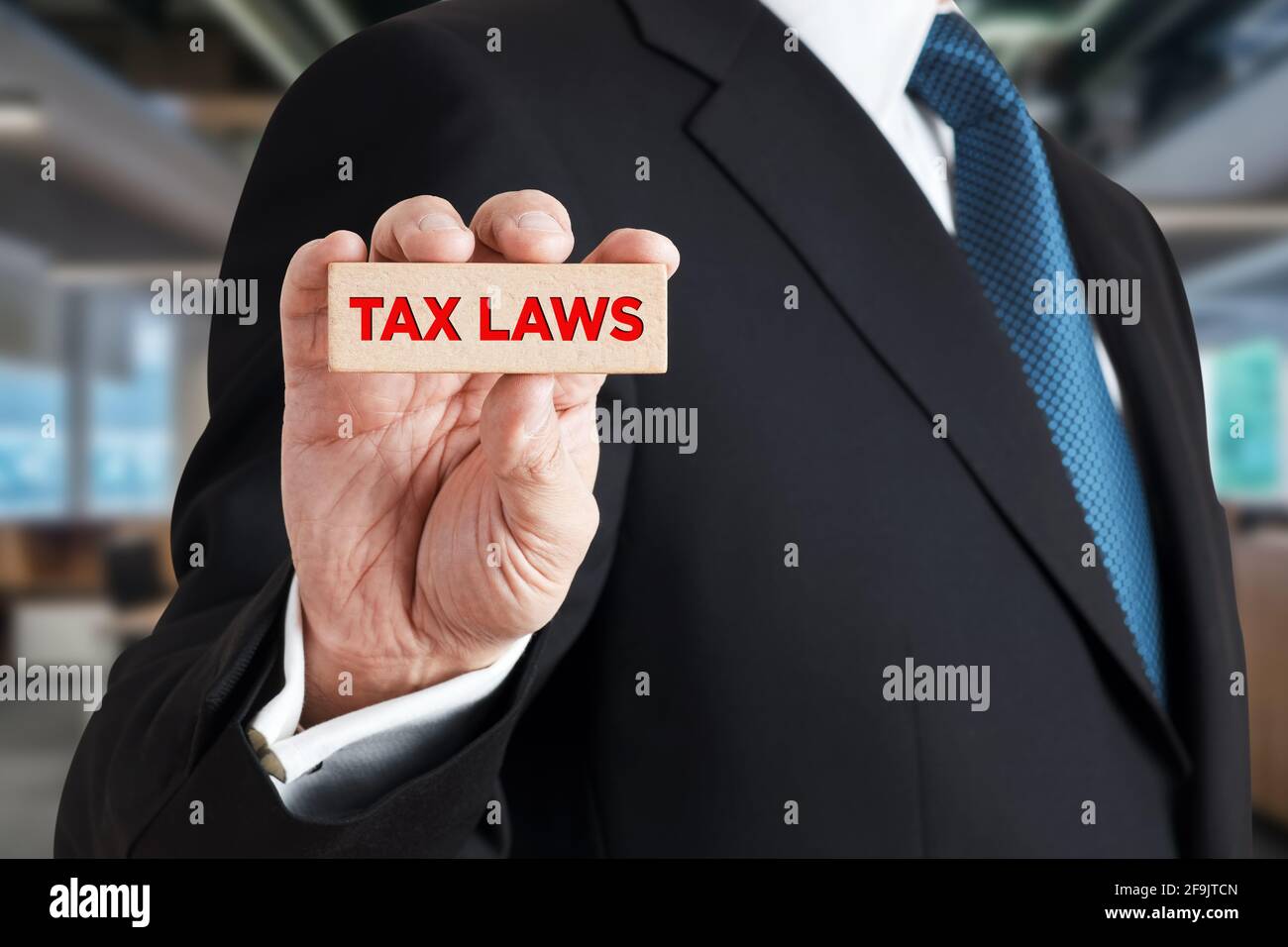 Homme d'affaires montre un bloc de bois avec le mot lois fiscales. Fiscalité et droit financement des affaires concept. Banque D'Images