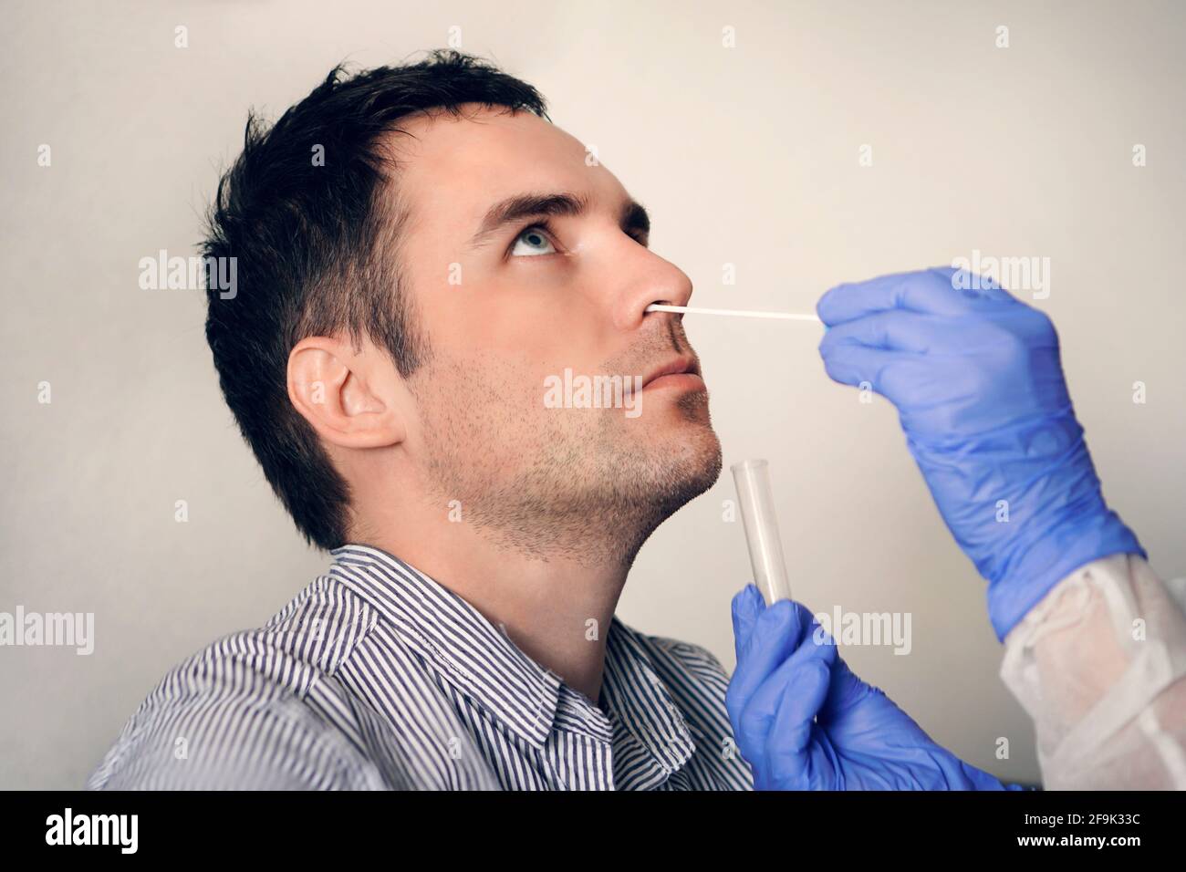 médecin prenant un échantillon de test de mucus nasal du nez mâle effectuant une procédure de test de virus respiratoires. Vérification de la cavité nasale dans l'ENT. Polymère PCR Banque D'Images
