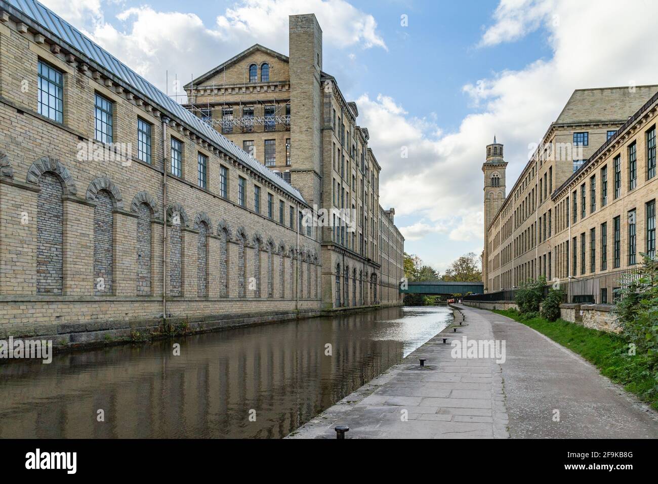 Les bâtiments de Salts Mill des deux côtés du canal Leeds Liverpool à Saltaire, dans le West Yorkshire. Banque D'Images