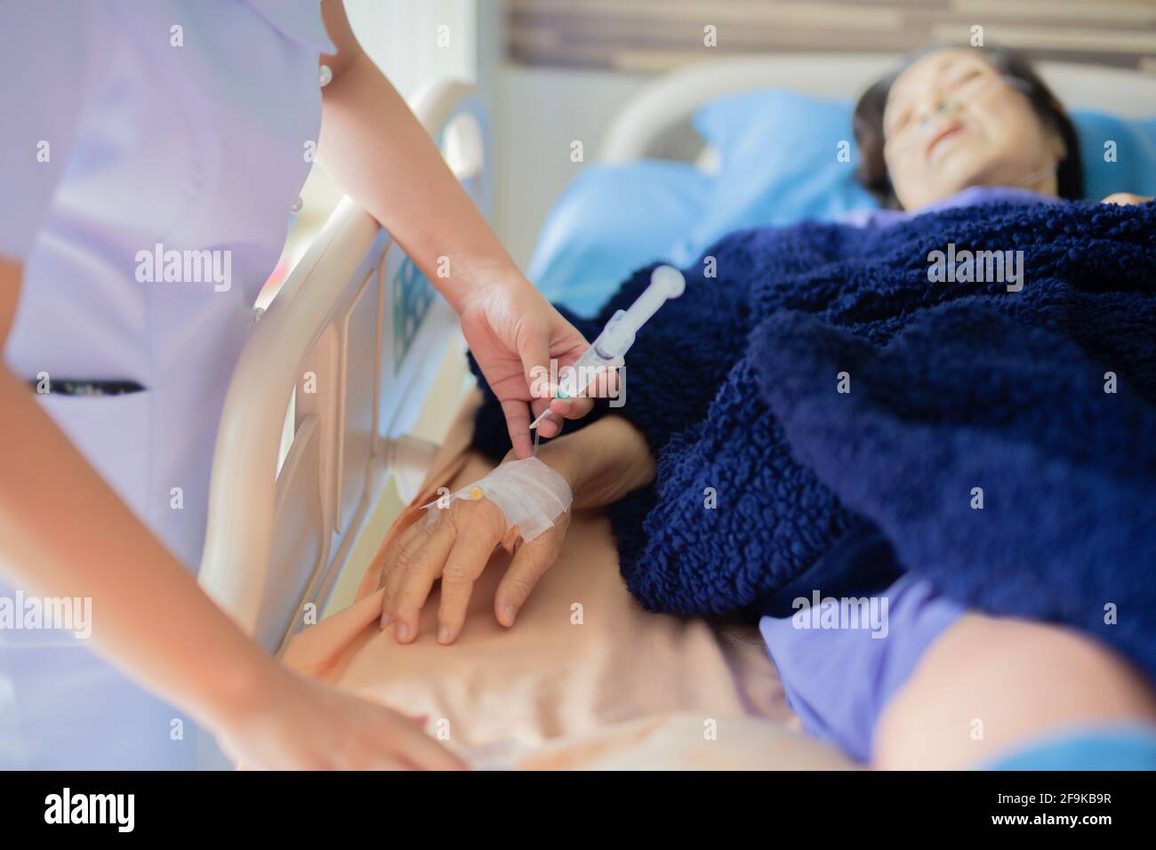 Infirmière administrant une injection à un patient de l'hôpital. Banque D'Images