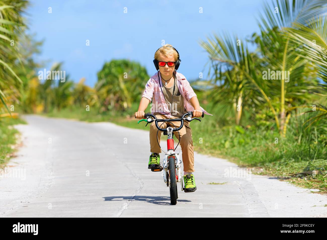 Randonnée à vélo. Jeune enfant pilote dans un casque et des lunettes de soleil à vélo. Un enfant heureux s'amuse sur le sentier. Mode de vie familial actif, sport Banque D'Images