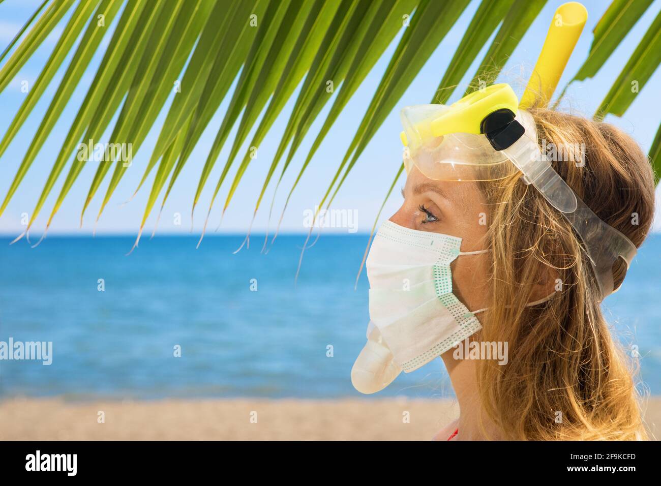 Drôle de fille dans les masques médicaux et de plongée libre sur la plage de mer. Nouvelles règles pour le port de couvre-visage dans les lieux publics. Croisière annulée, excursion due au coronavirus COVI Banque D'Images