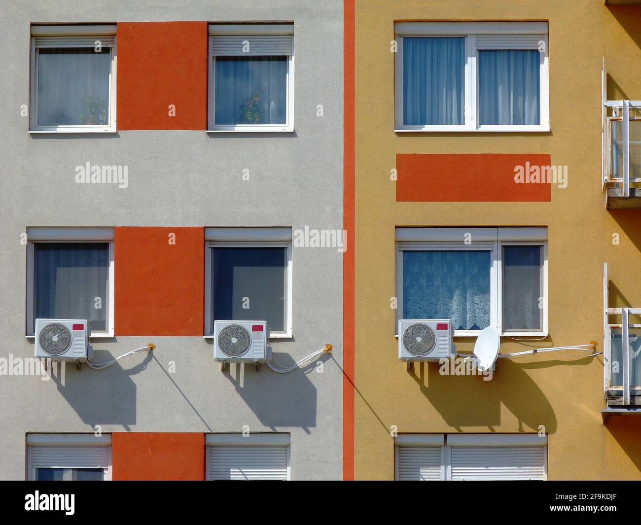 climatiseurs muraux installés. cache-radiateur. fenêtres résidentielles sur le mur extérieur ou la façade de l'immeuble d'appartements. élévation en stuc Banque D'Images