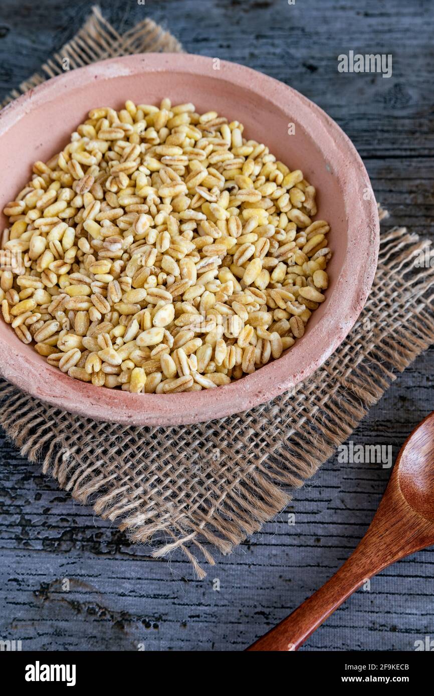 Grains de blé non cuits cultivés en france sur fond rustique Banque D'Images