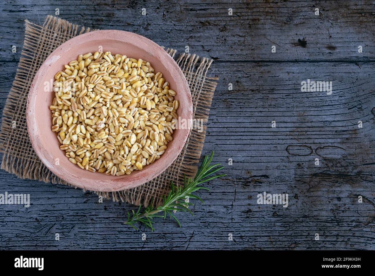 Grains de blé non cuits cultivés en france sur fond rustique Banque D'Images