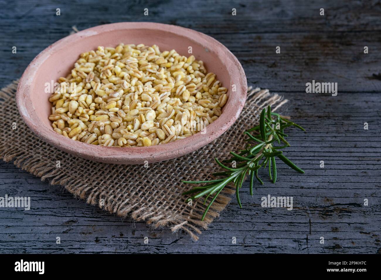 Grains de blé non cuits cultivés en france sur fond rustique Banque D'Images