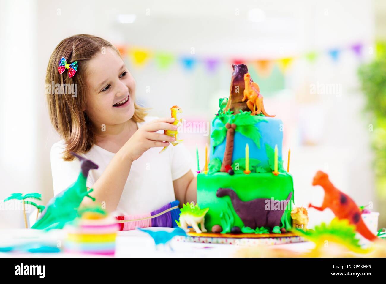 Fete D Anniversaire Pour Enfants Gateau Sur Le Theme Des Dinosaures Petites Filles Soufflant Bougies Et Ouverture De Cadeaux Evenement Enfants Decoration Pour Les Dinosaures Photo Stock Alamy