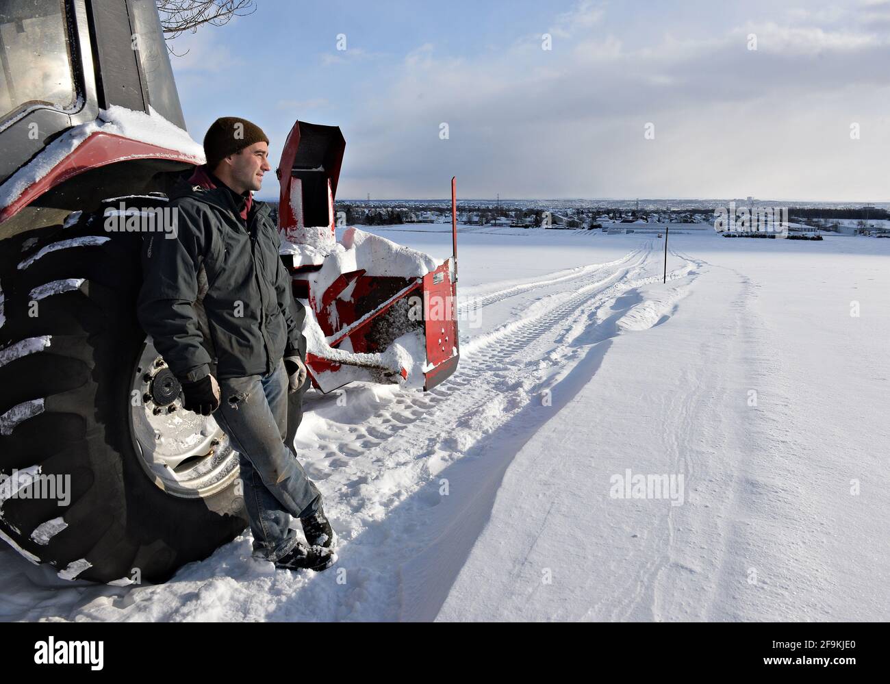 agriculteur et son tracteur en hiver Banque D'Images