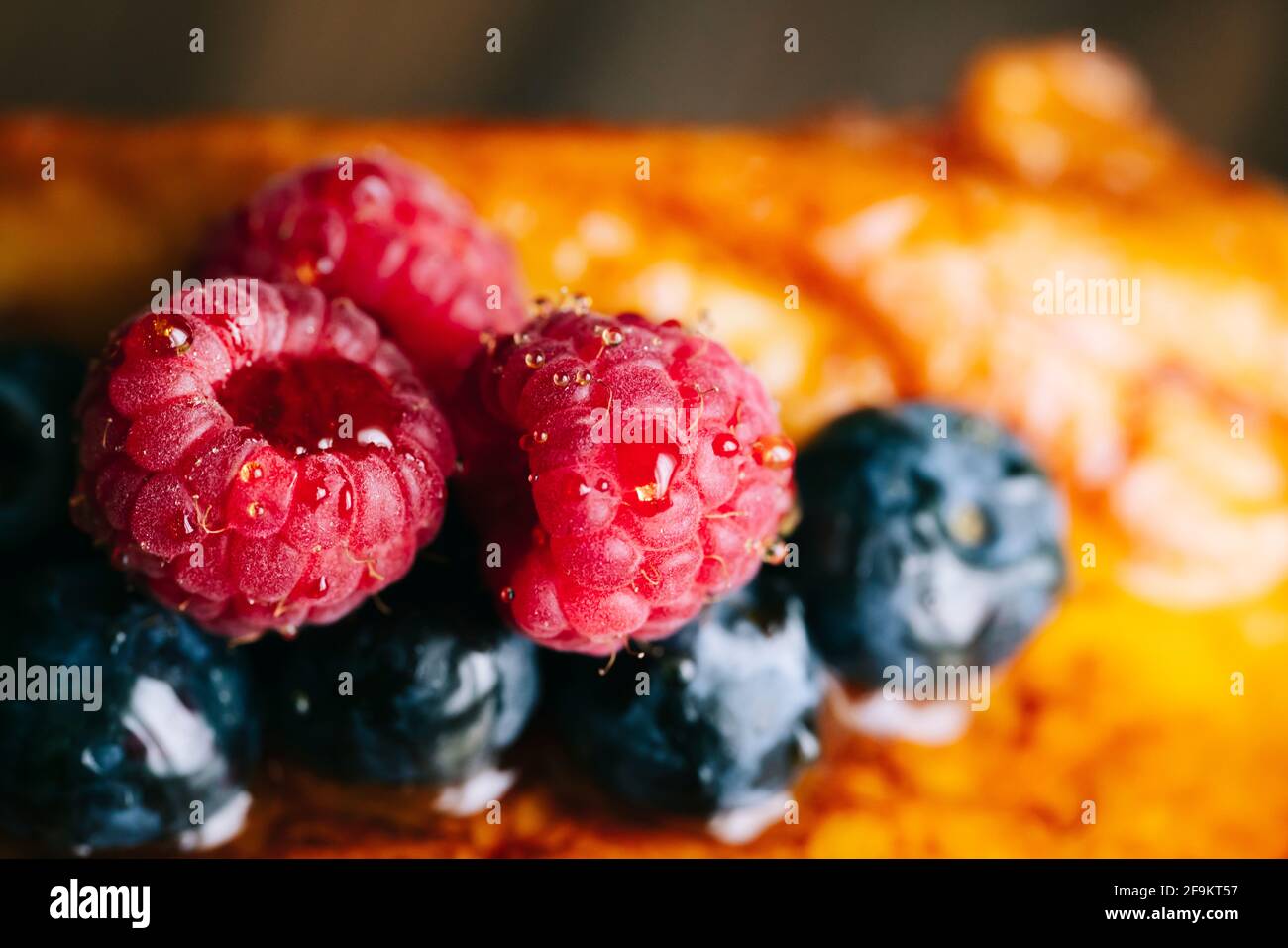 Détail des framboises rouges sur le pain frit avec gouttes de miel Banque D'Images