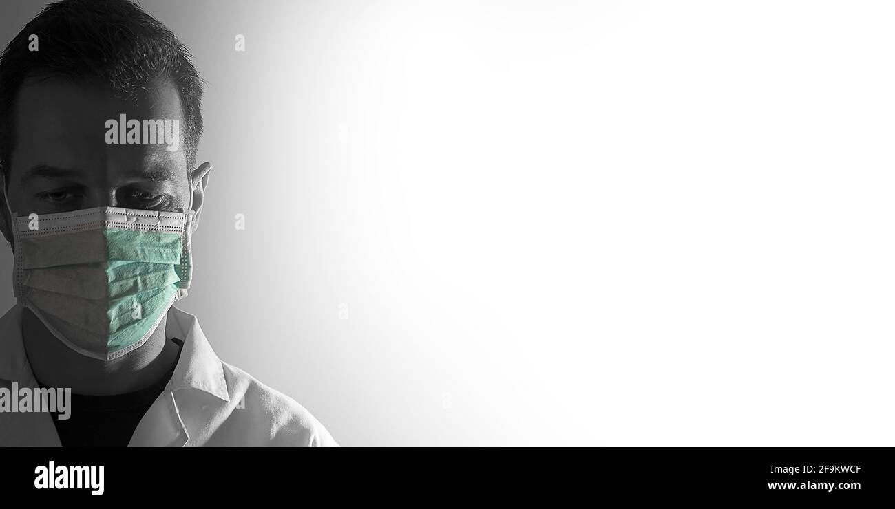 Portrait d'un médecin en noir et blanc avec un masque de protection sur fond blanc dégradé Banque D'Images