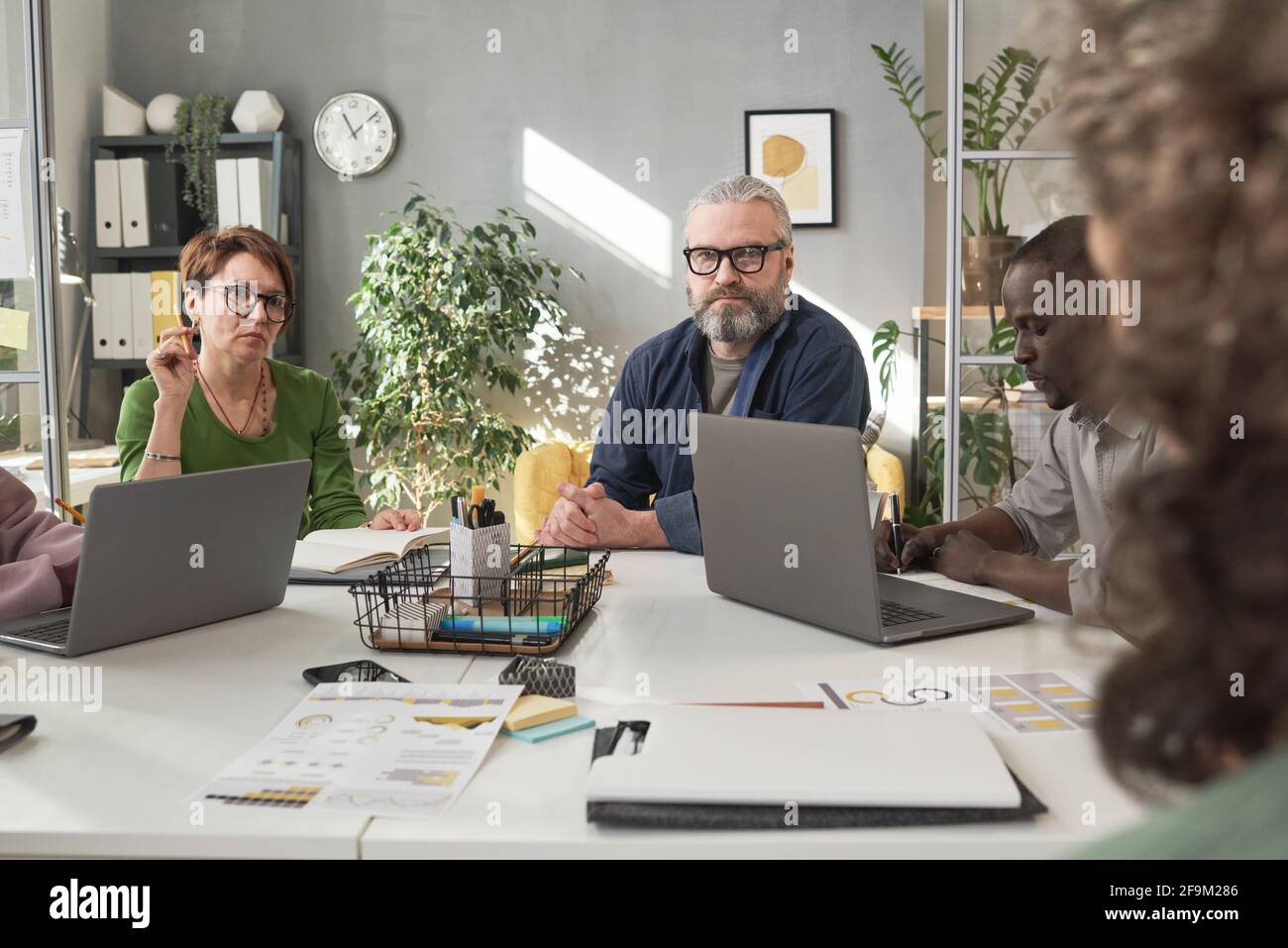 Les gens d'affaires assis à la table avec des ordinateurs portables et travaillant en équipe lors d'une réunion d'affaires Banque D'Images