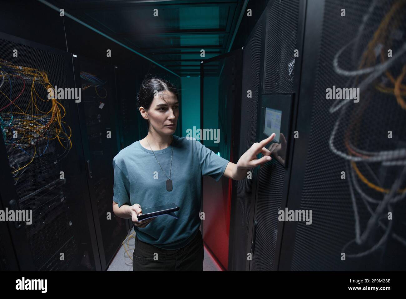 Portrait à la taille de la femme militaire à l'aide du panneau de configuration lors de la configuration des serveurs dans le centre de données, espace de copie Banque D'Images