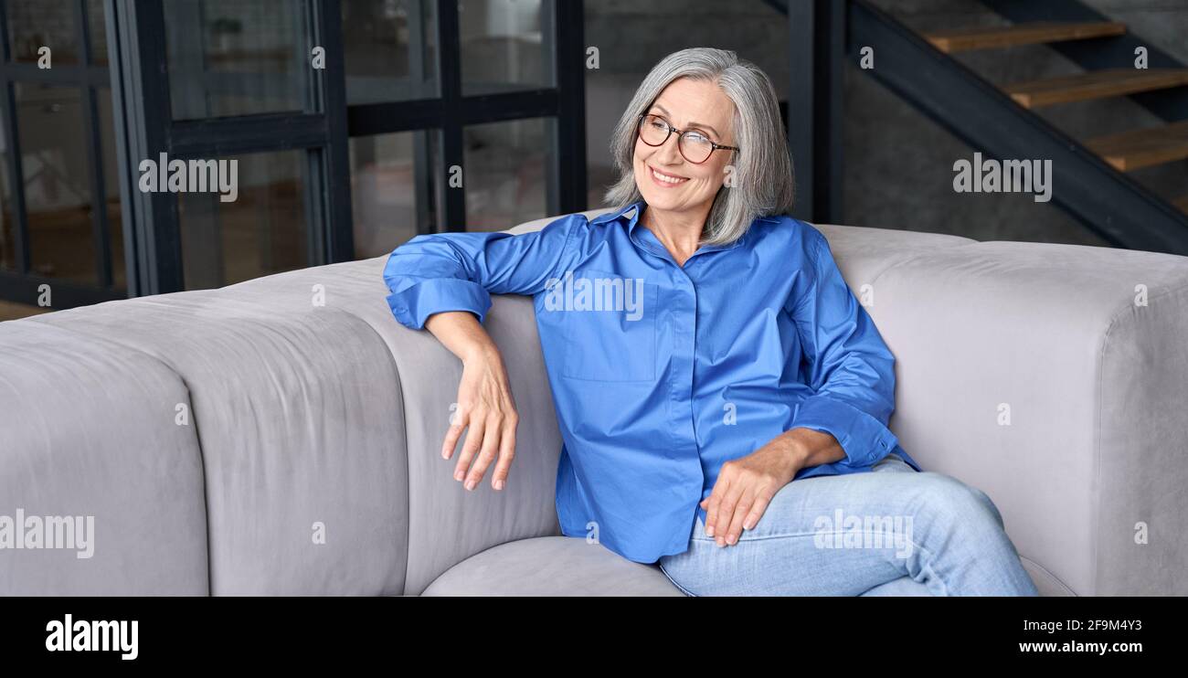 Femme âgée de milieu de gamme dans des lunettes qui profite du bien-être et de la vision de l'avenir. Banque D'Images