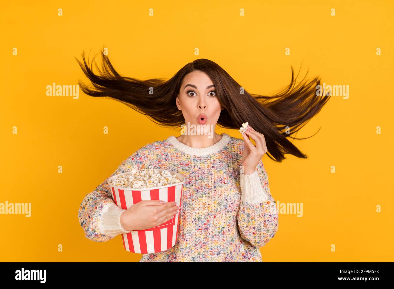Photo de la jeune femme surprise surpris cheveux mouche tenir manger pop  corn watch tv isolé sur fond jaune Photo Stock - Alamy