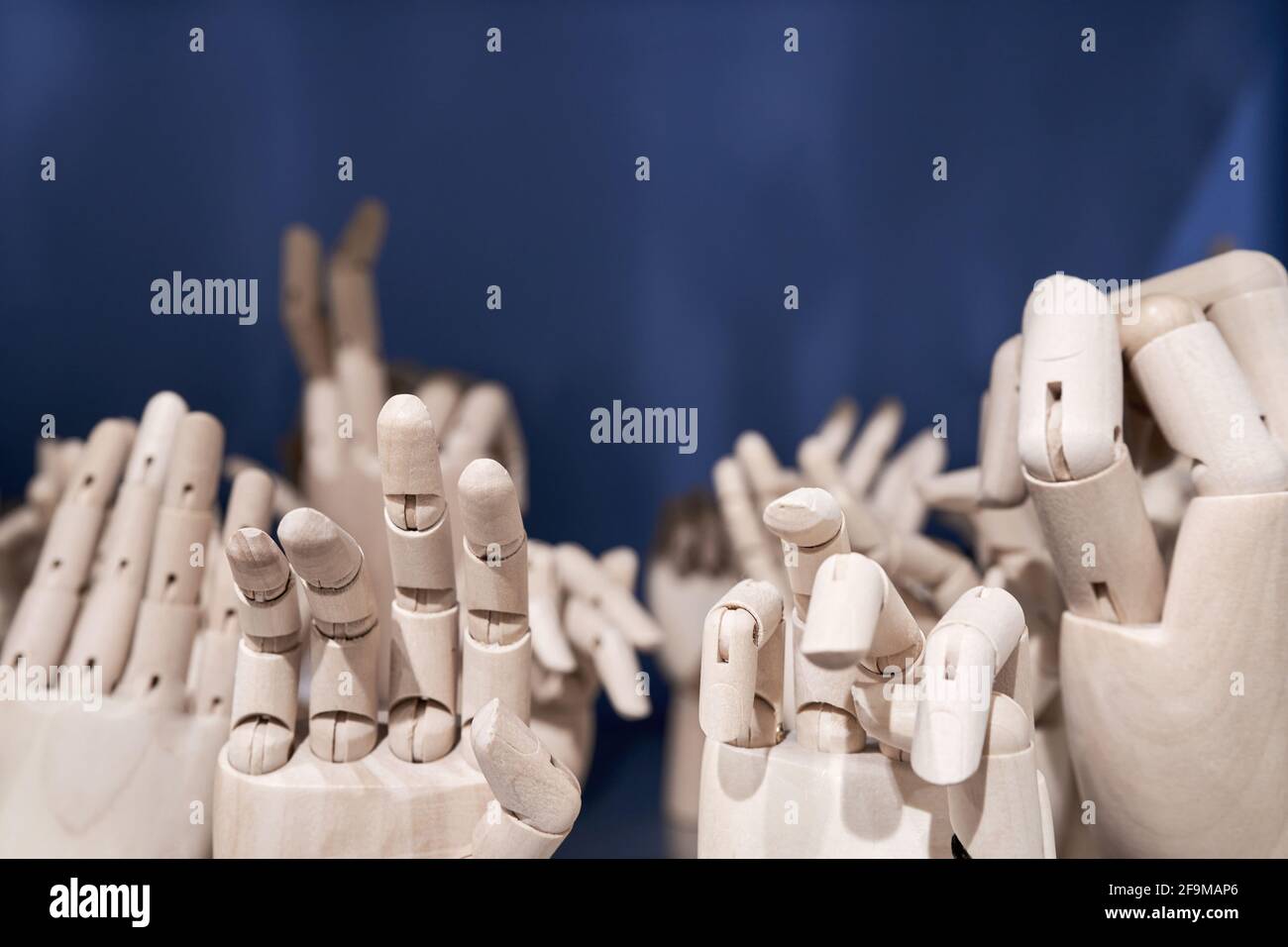 Maquette en bois Human Hands Gesture set sur étagère sur fond bleu gros plan. Collection de mannequins pour les mains en gros plan. Banque D'Images