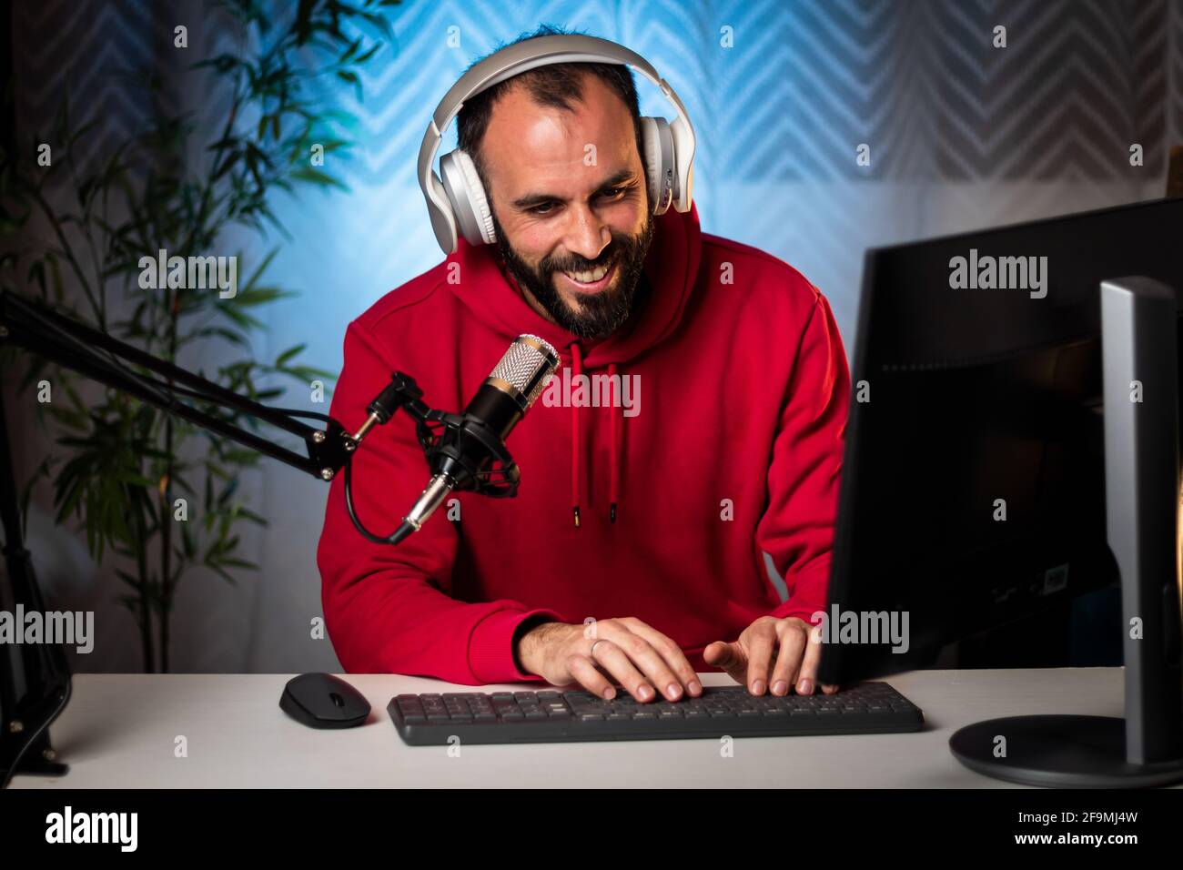 Créateur de contenu avec casque et microphone pour diffuser un programme en ligne sur Internet. Balado présentateur diffusant un programme en direct. Enregistrement de contenu pour un programme Internet. Banque D'Images