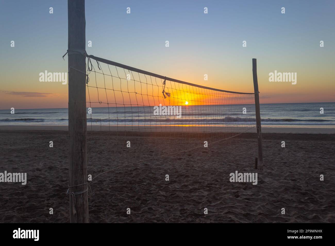Terrain de volley-ball sans joueurs au lever du soleil. Banque D'Images
