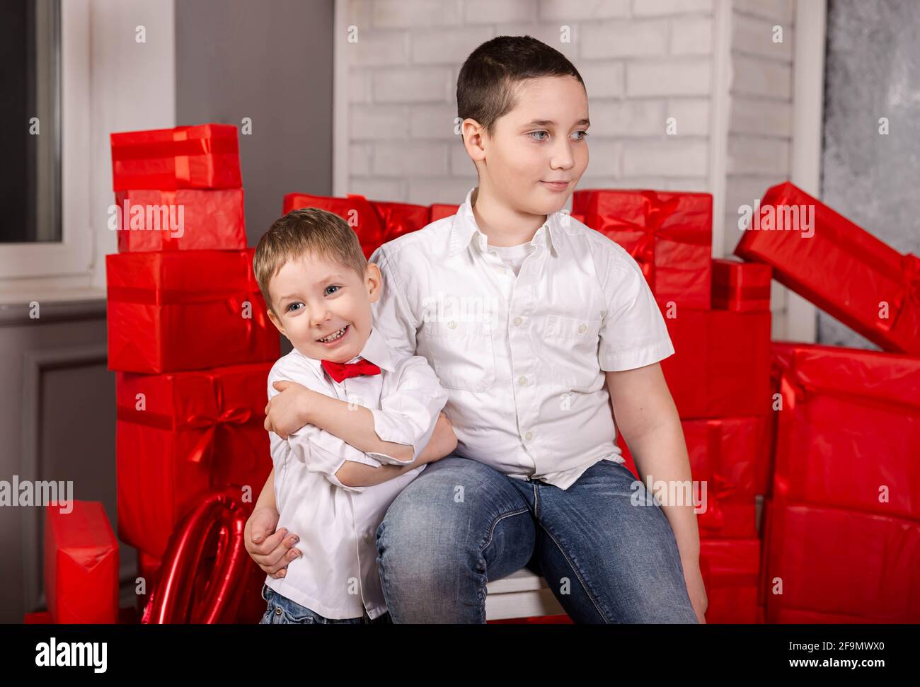 Joyeux mignon enfants garçon donner cadeau à un ami. Deux beaux enfants. Banque D'Images