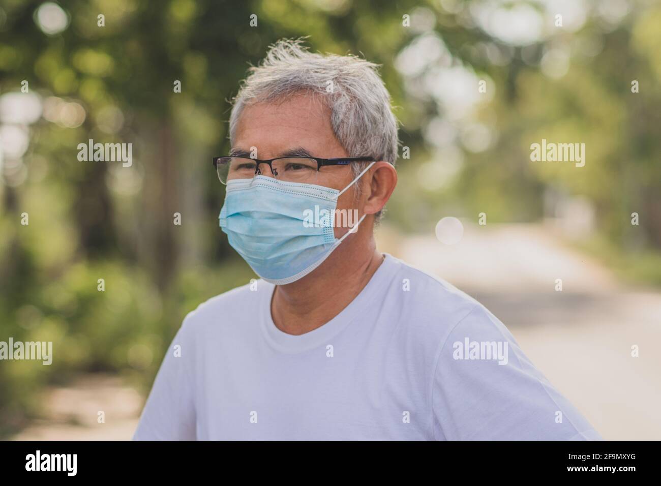 Vieux homme porter un masque chirurgical protéger le coronavirus covid19 à  l'extérieur Ville parc style de vie nouveau normal, homme retraité  s'exerçant dans le matin Photo Stock - Alamy