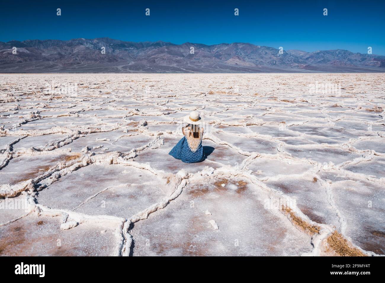 Salt Flats dans le parc national de la Vallée de la mort. Silhouette d'une femme qui profite de la vue. Sentier de randonnée de Badwater Basin, aventure de sentier à travers les plaques de sel bouleversements Banque D'Images