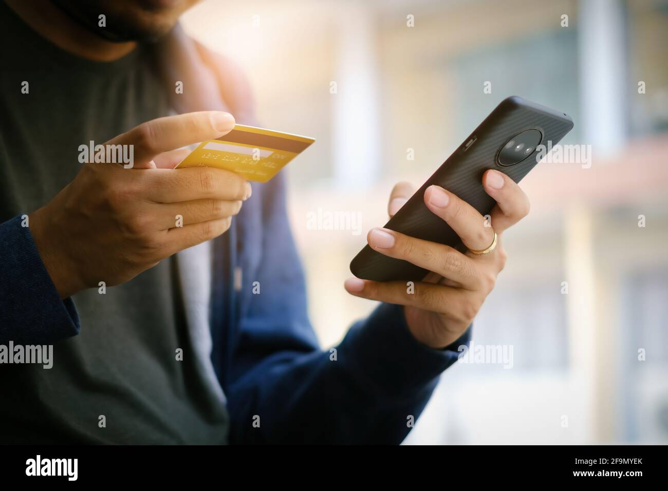 Un jeune homme effectue un achat sur Internet sur le smartphone avec une carte de crédit. Achat en ligne concept.. Banque D'Images