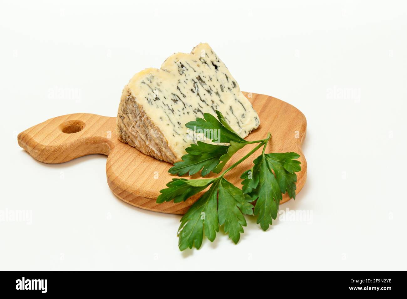 Fromage Fourme d'Ambert et persil sur planche à découper en bois Banque D'Images