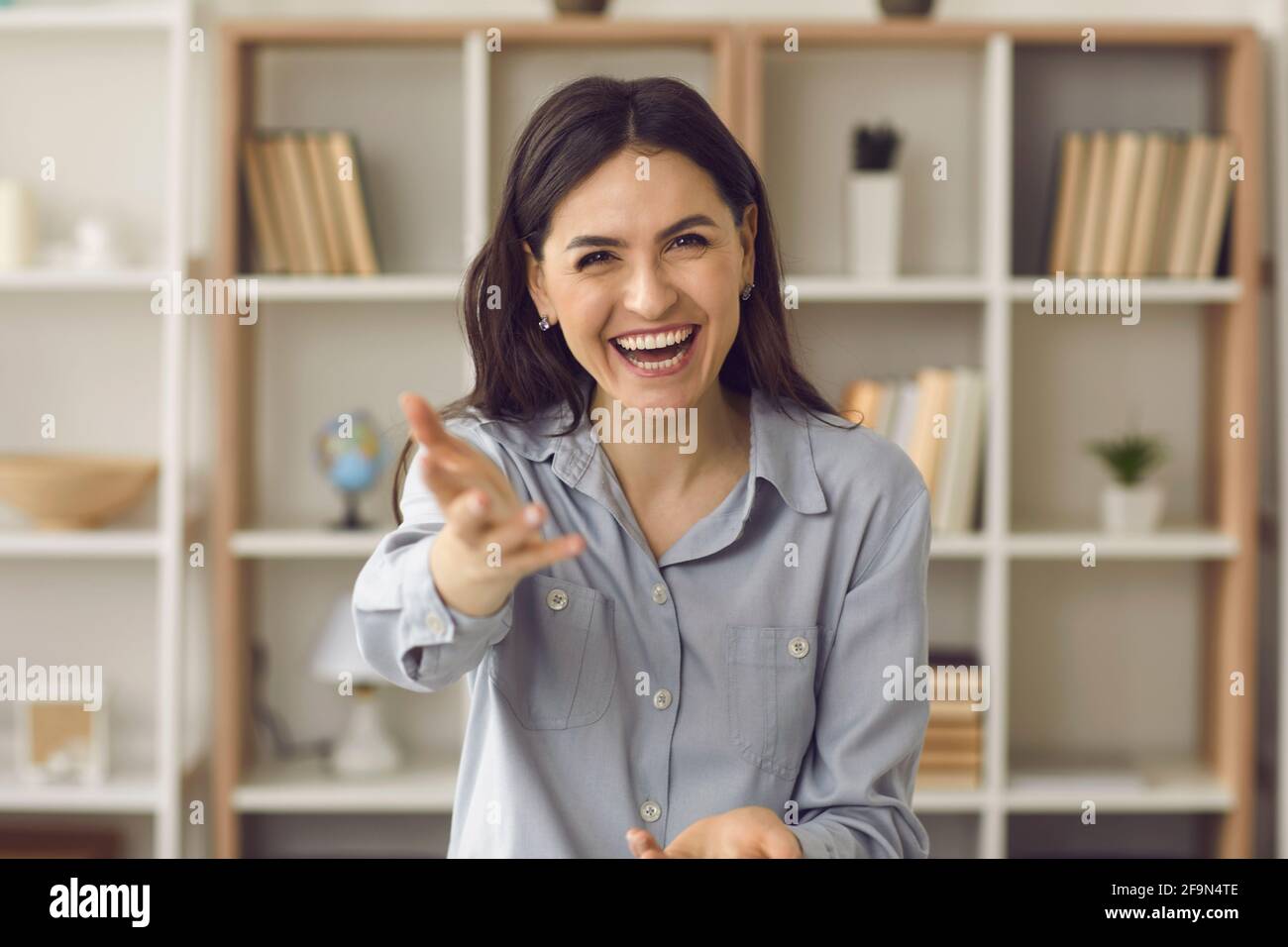 Webcam portrait de jeune femme gaie tenant la main encourageante vous à parler Banque D'Images