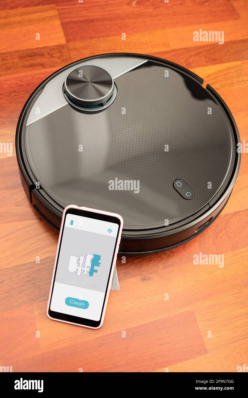 Robot aspirateur automatique pour nettoyer le sol et aider dans les travaux  ménagers contrôlés par un smartphone avec une application maquette Photo  Stock - Alamy