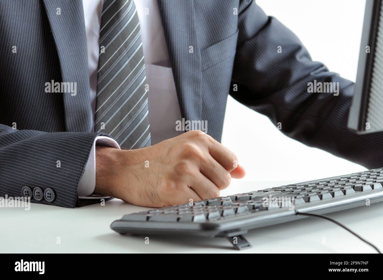 Homme d'affaires se crampissant à sa poing sur la table de travail - irrité, pensif et déterminé concept Banque D'Images