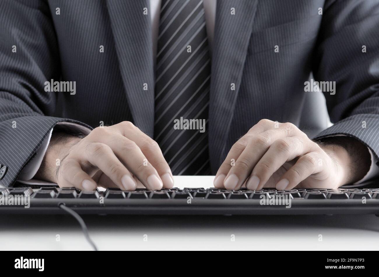Homme d'affaires mains dactylographiant clavier d'ordinateur - style rétro éclairage effet Banque D'Images