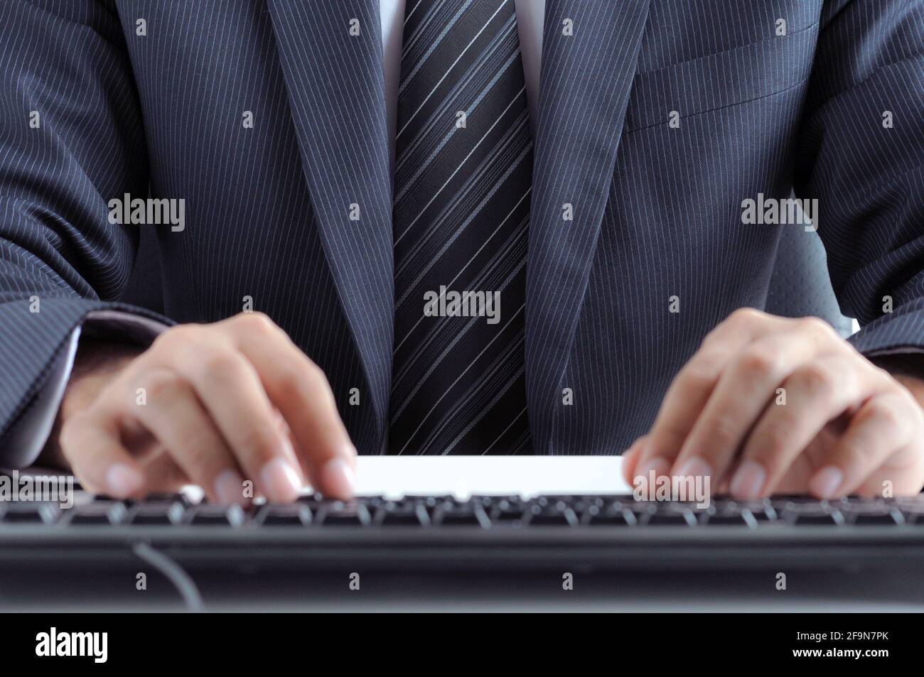 Homme d'affaires mains dactylographiant clavier d'ordinateur Banque D'Images
