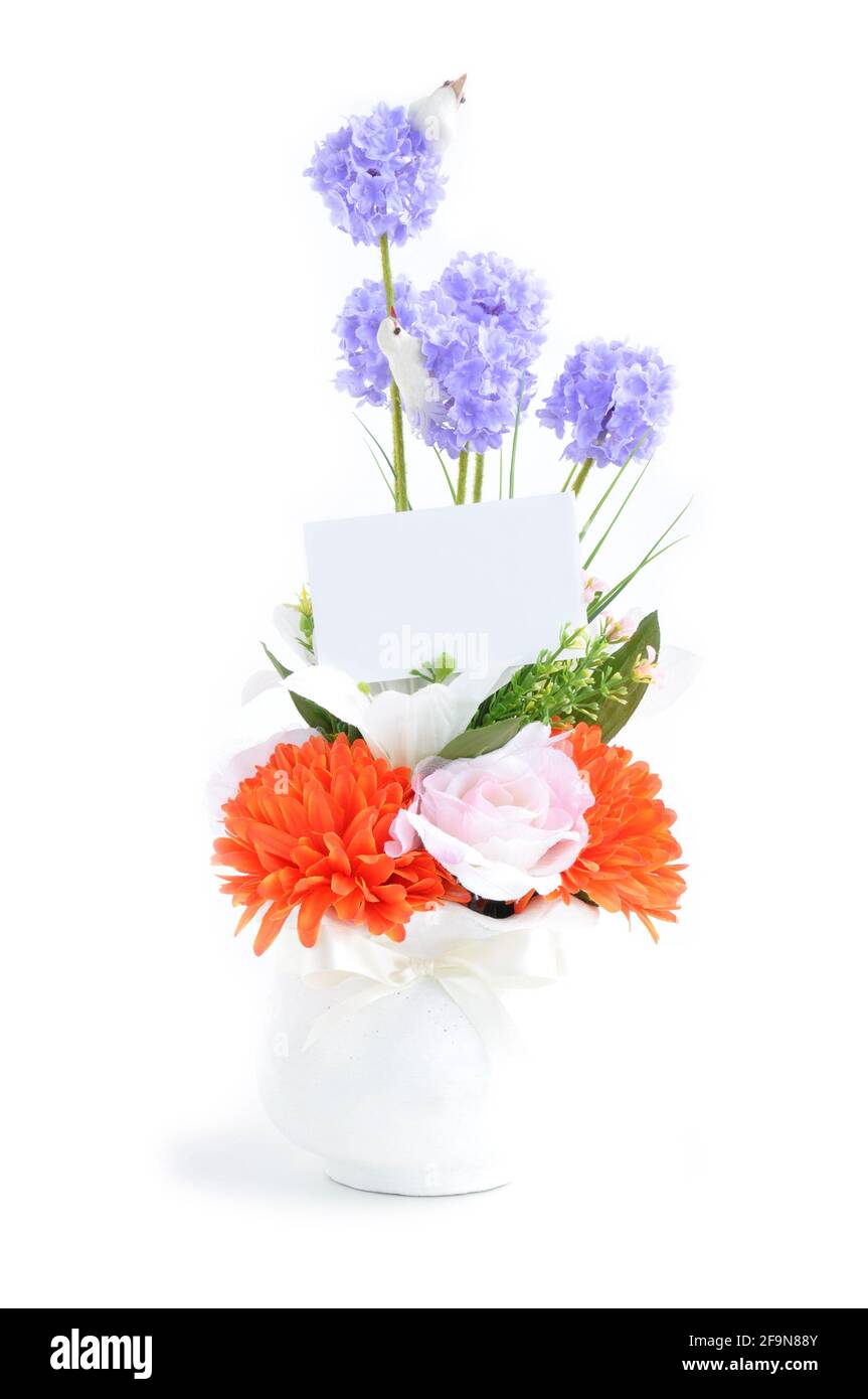 Bouquet de fleurs artificielles dans vase blanc avec carte vide - isolé Banque D'Images
