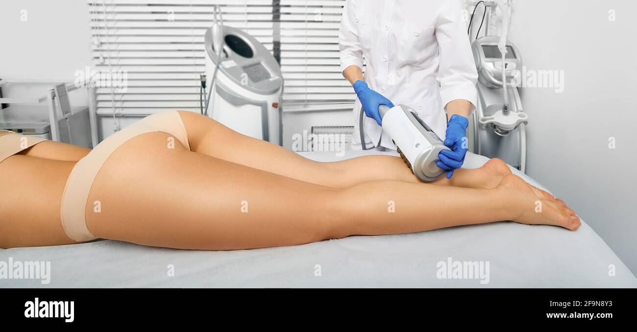 Femme pendant la thérapie des endosphères et le massage des jambes. Massage anti-cellulite dans un centre de beauté Banque D'Images